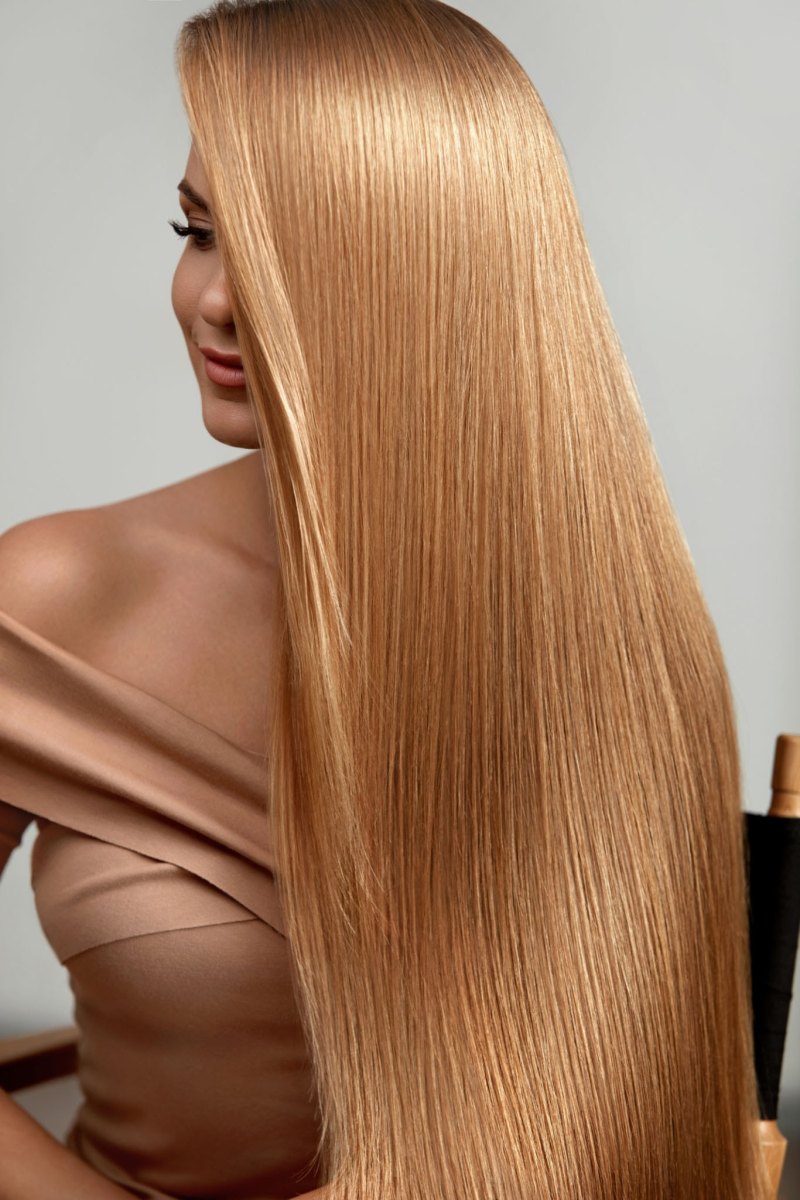 Woman with ultra-glossy long golden honey blonde hair