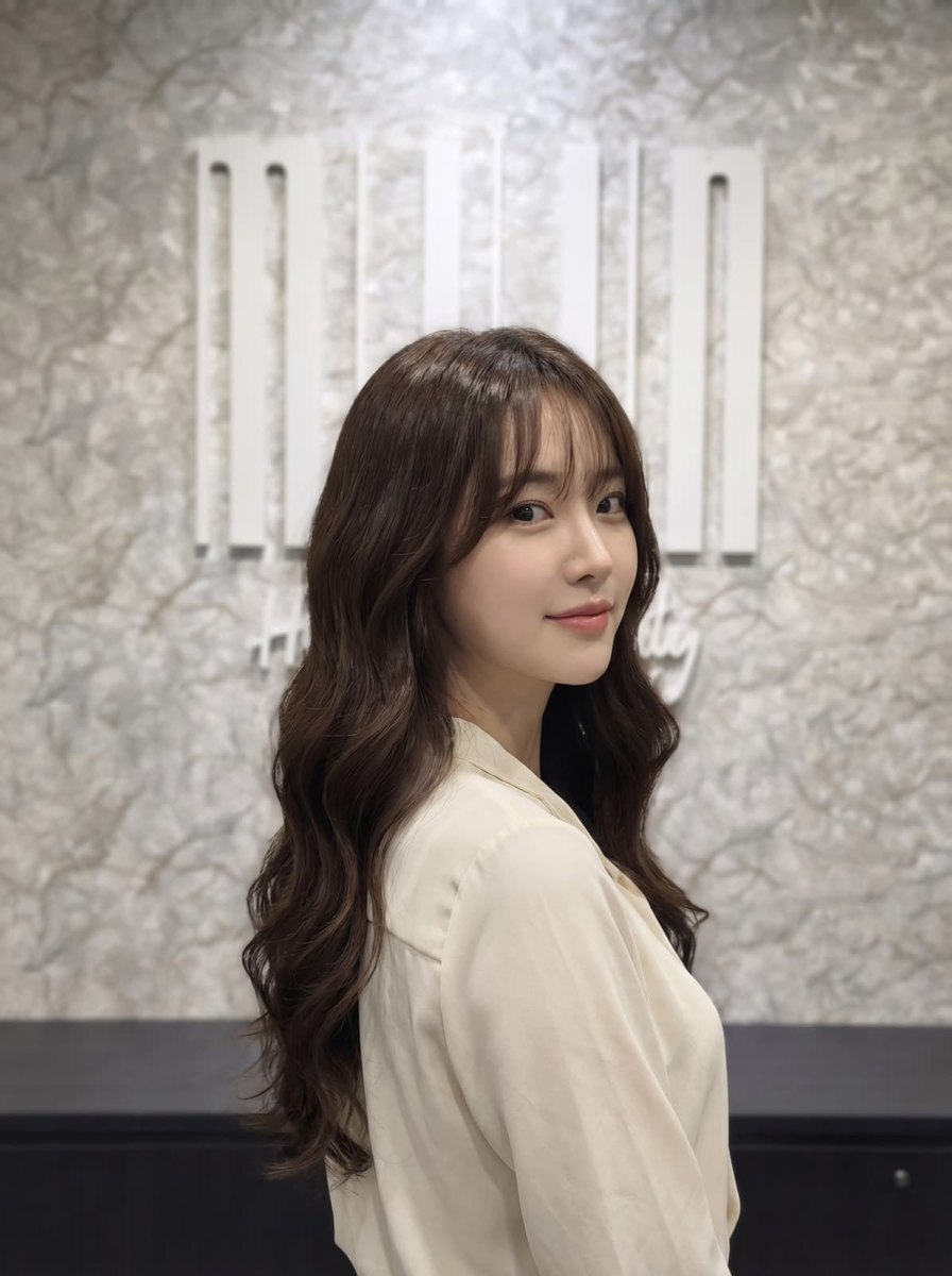 Long dark hair with romantic S-curl perm waves and wispy bangs