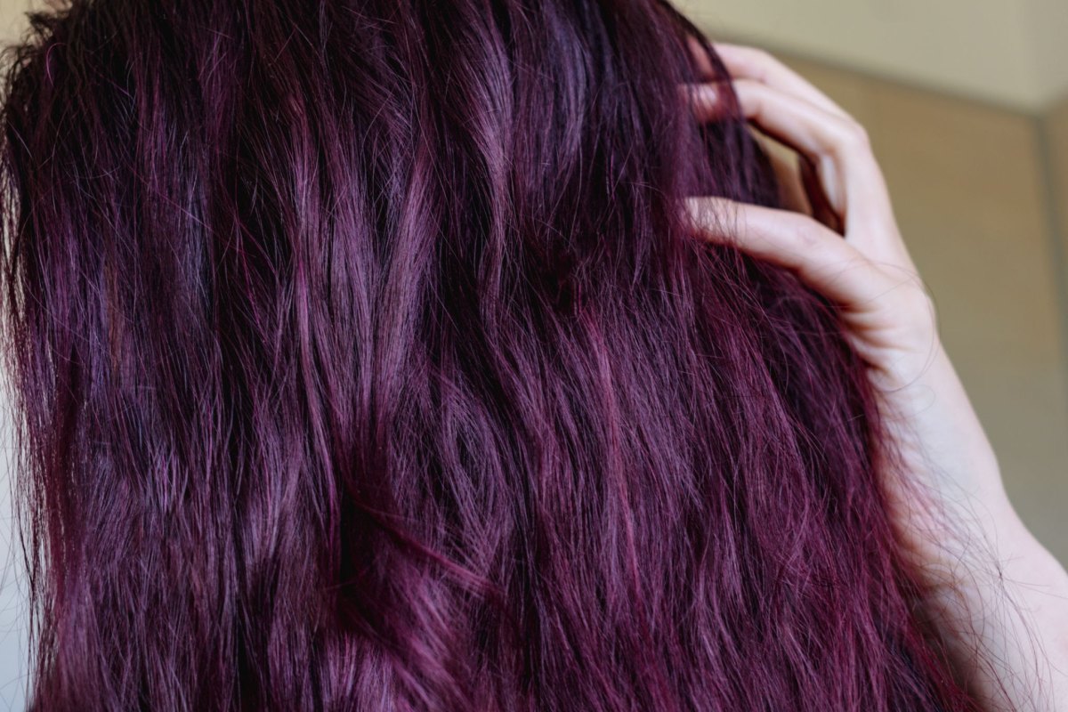 Close-up of wavy hair with intense dark violet and cherry cola undertones