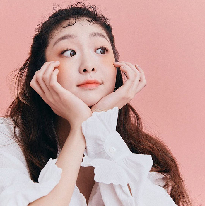 Young woman with playful curly permed Korean wispy bangs and wavy hair