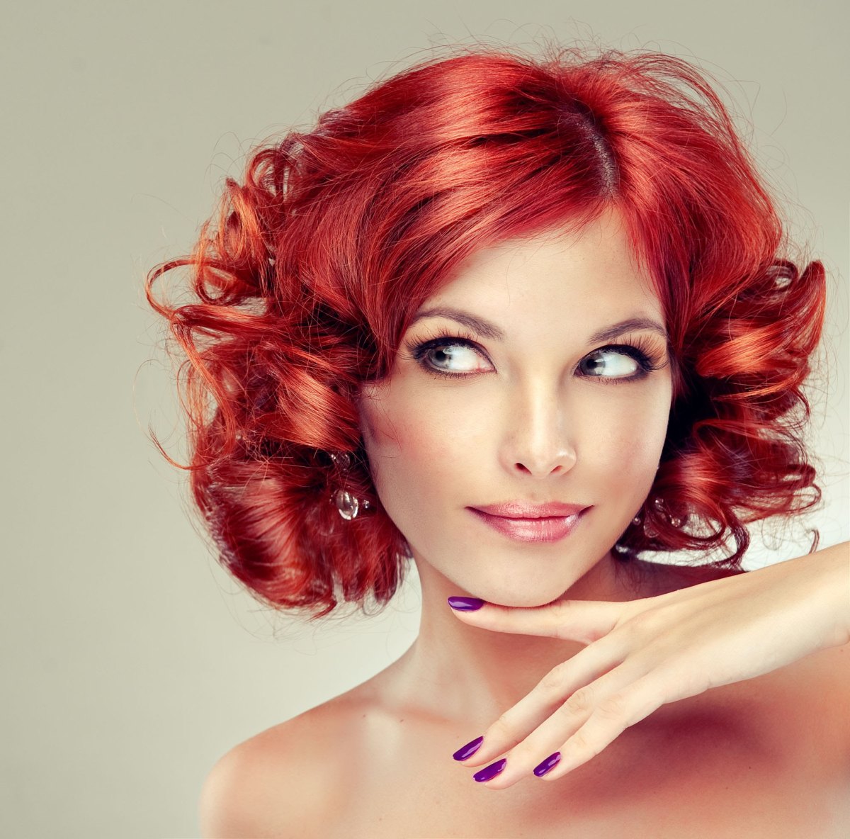 Woman with vibrant cherry red bouncy curls in a rounded vintage short cut