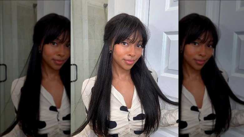 Half-up half-down long dark hair styled with breezy Korean wispy bangs