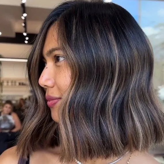 Dark brown lob haircut with subtle honey blonde balayage ribbons