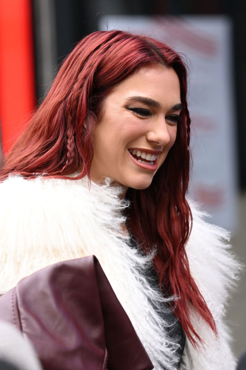 Wavy layered cherry red hair outdoors in bright daylight