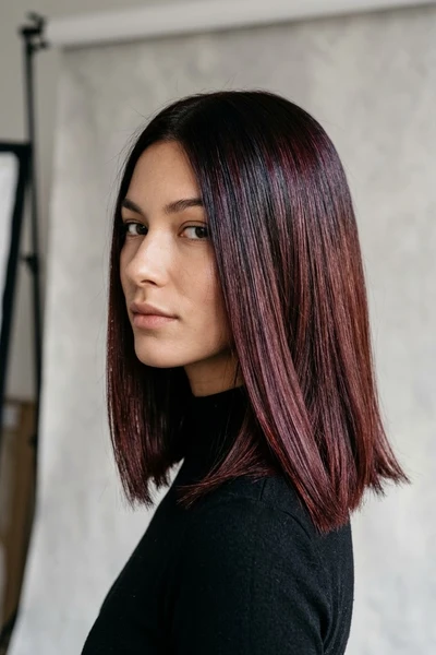 Shoulder-length sleek straight blunt cut with glossy dark cherry cola tones