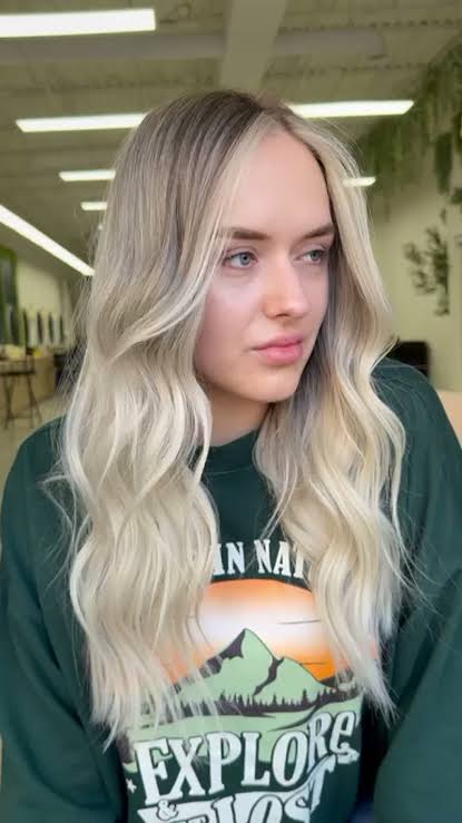 Bright face-framing blonde balayage money piece on wavy hair