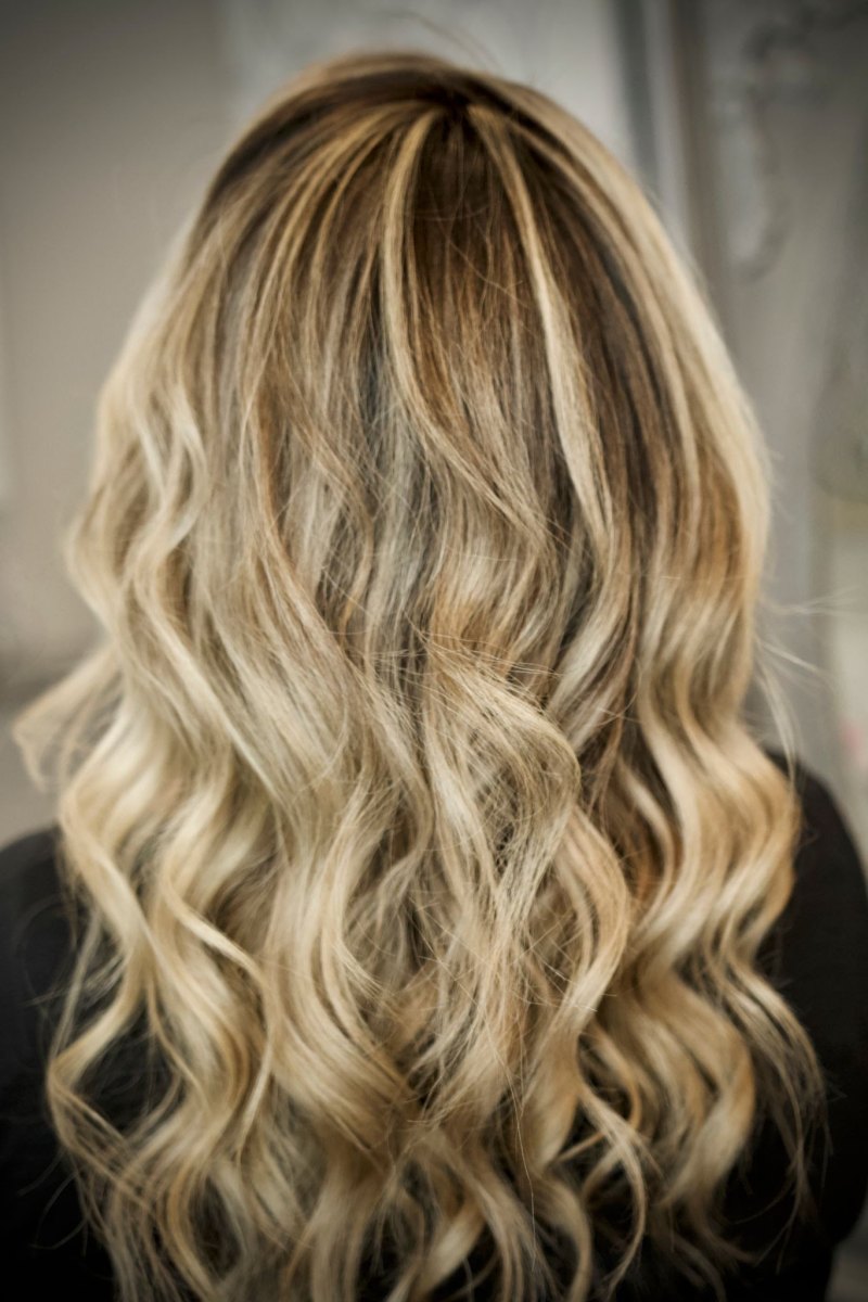 Back view of curled hair with caramel and honey blonde balayage