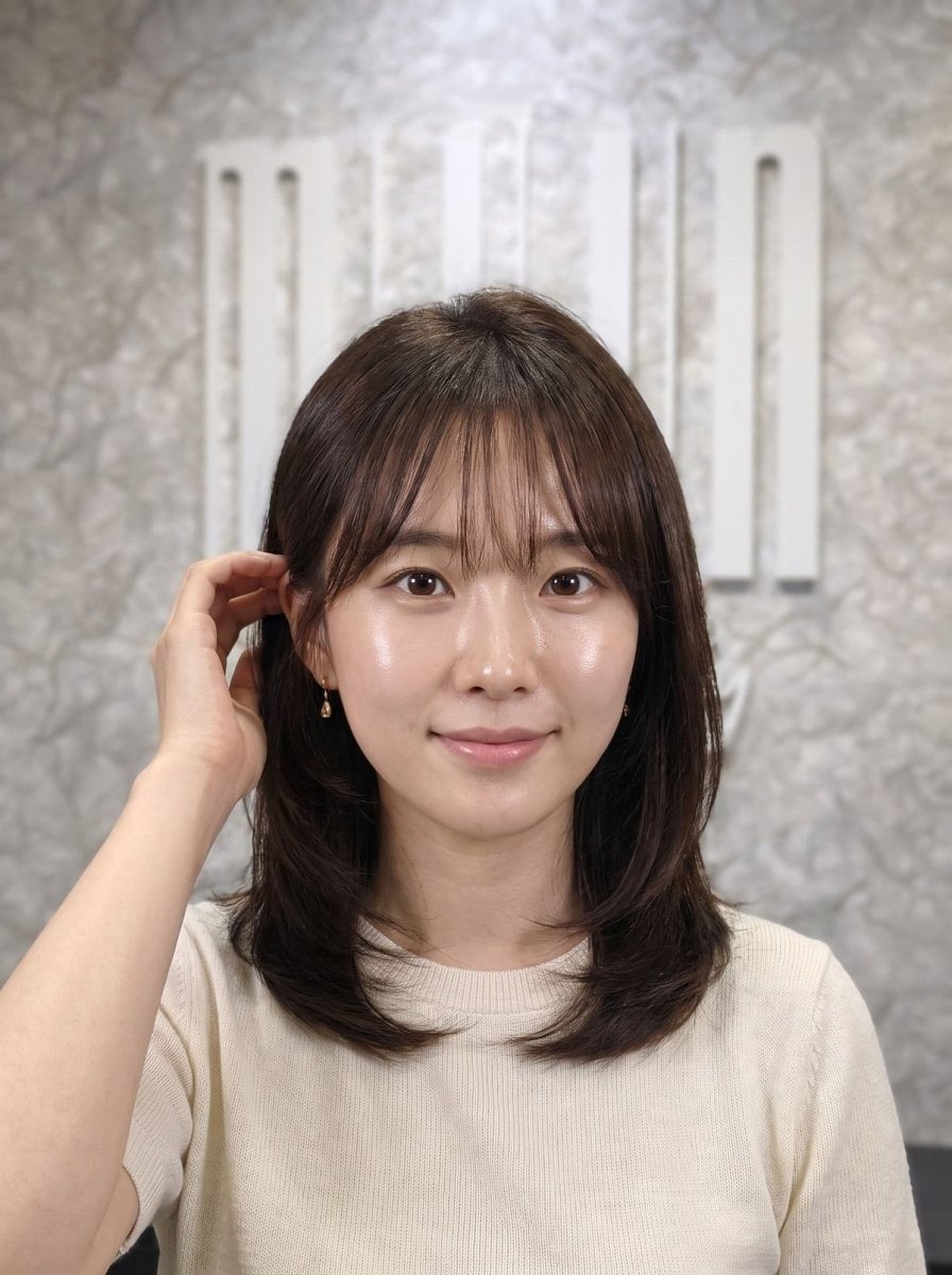 Medium-length Korean hush cut with light layers and wispy bangs