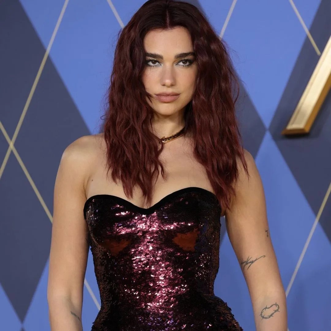 Wavy dark cherry red hair worn loose on a red carpet