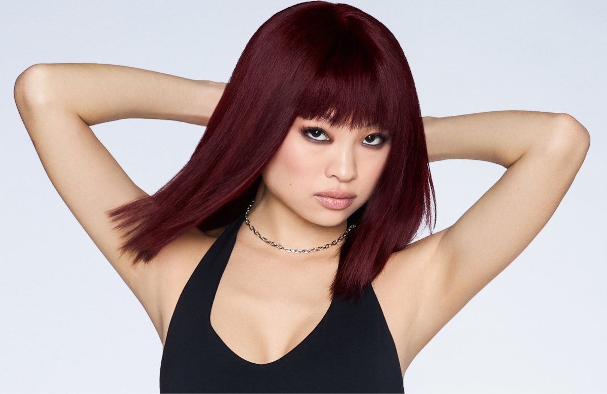 Sleek lob with full fringe bangs in a deep plum cherry cola shade