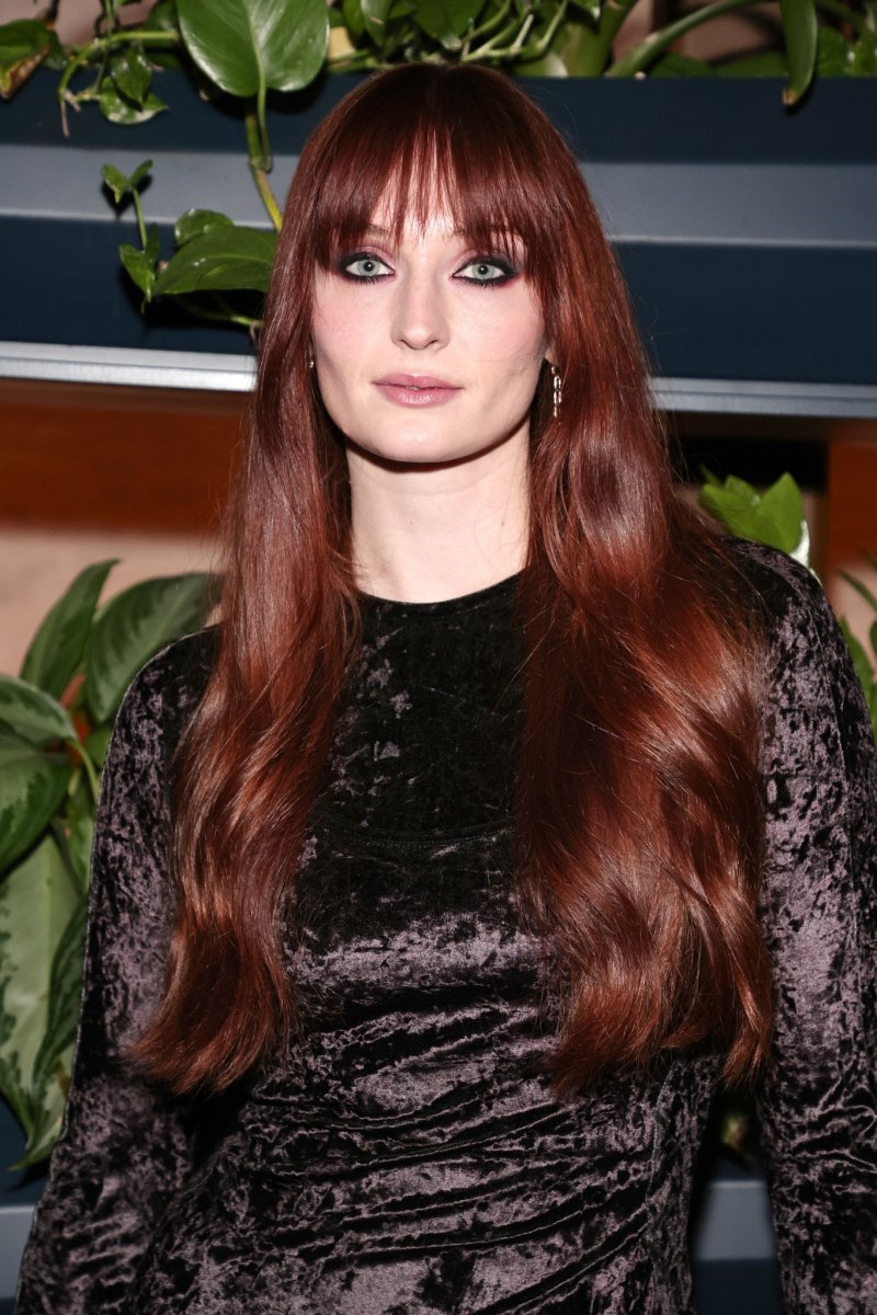 Long wavy hair with bangs in a warm mahogany cherry brown shade