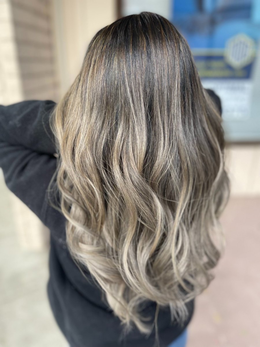 Back view of salon balayage blend on long wavy hair